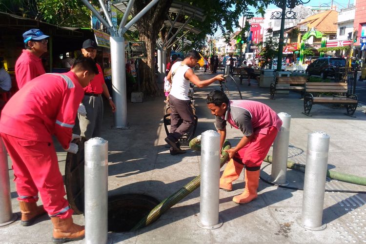 Petugas membersihkan lubang perangkap lemak di jalur pedestrian Jalan Malioboro, Kota Yogyakarta, Jumat (11/8/2017). Ratusan aparatur negara membersihkan Jalan Malioboro dari kotoran dan sampah.