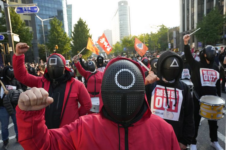 Anggota Konfederasi Serikat Buruh Korea Selatan yang mengenakan topeng dan kostum yang terinspirasi oleh serial Netflix Korea asli Squid Game meneriakkan slogan-slogan selama rapat umum menuntut keamanan kerja di Seoul, Korea Selatan, Rabu, 20 Oktober 2021. 