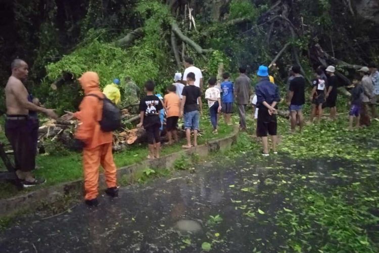 Warga tengah bergotong royong membersihkan material pohon tunbang yang menutup jalan di Bandung Barat, Senin (9/5/2022).