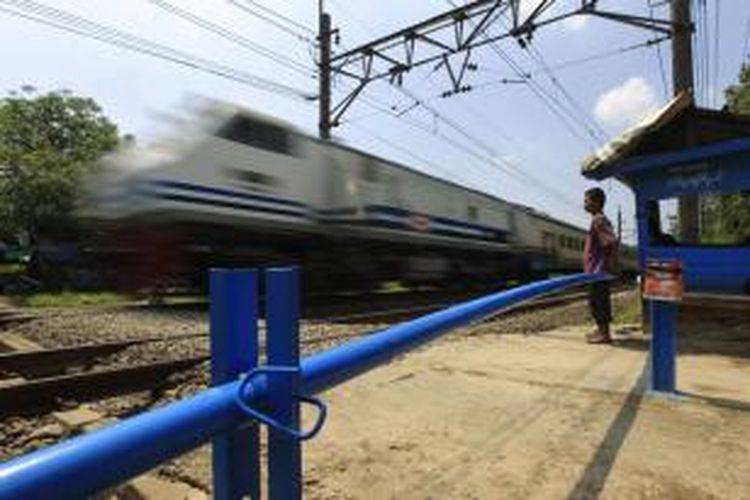 Warga menjaga palang pintu darurat perlintasan kereta api di Kampung Sumur, Klender, Jakarta Timur, Kamis (19/5/2011). Warga sekitar membuat palang pintu secara swadaya untuk menghindari kecelakaan lalu lintas di perlintasan kereta api.  