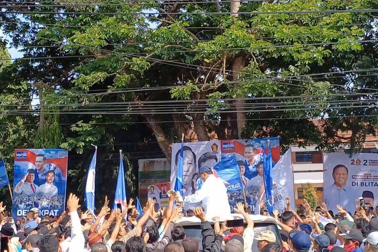 Calon presiden (capres) nomor urut 2, Prabowo Subianto membagikan kaos ke pendukungnya di Blitar, Jawa Timur, Minggu (17/12/2023).