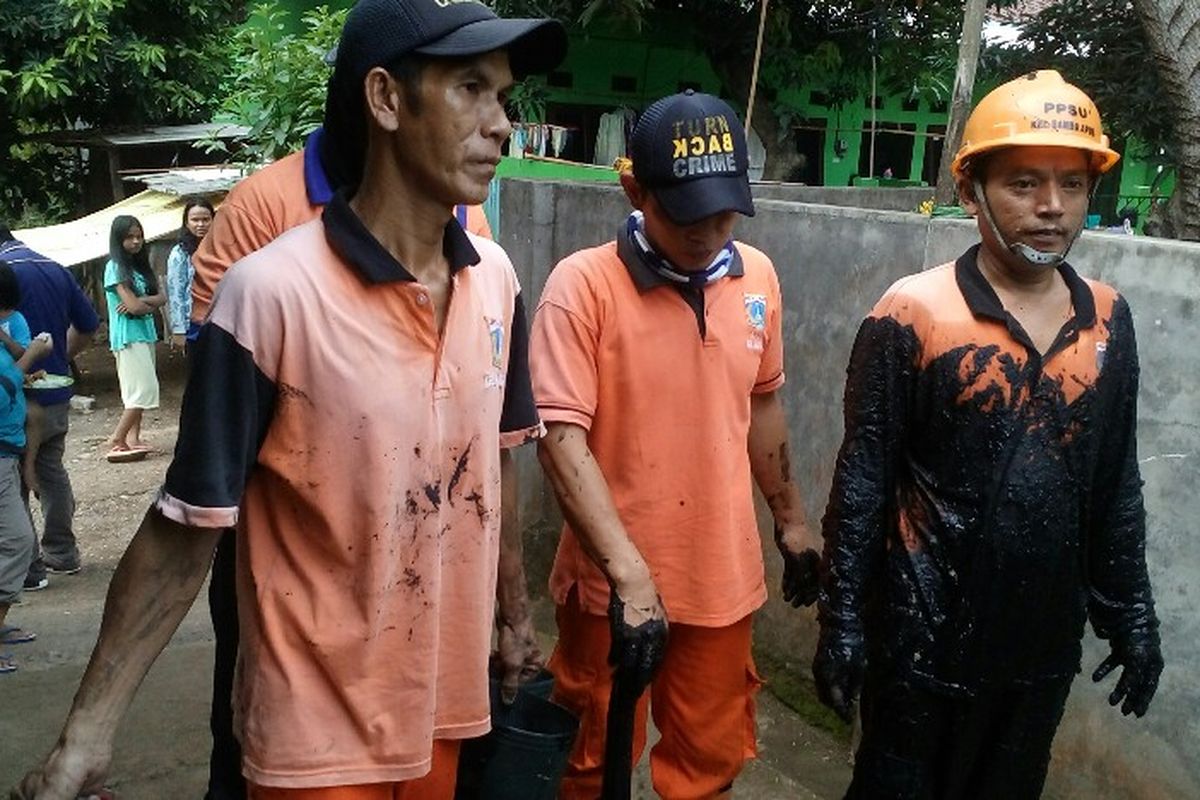 Sejumlah petugas Penanganan Sarana dan Prasarana Umum (PPSU) atau sering disebut pasukan oranye terlihat berjalan meninggalkan lokasi penggeledahan sebuah rumah di Cipayung, Selasa (30/5/2017).