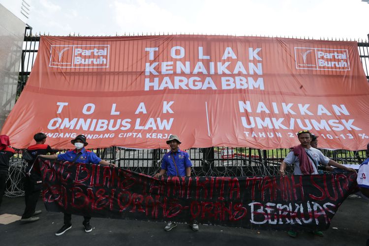 Massa dari elemen buruh melakukan demonstrasi di depan Gedung DPR/MPR RI, Jakarta, Selasa (6/9/2022). Mereka memasang spanduk berukuran besar hingga menutupi gerbang masuk utama kompleks parlemen untuk menolak kenaikan harga BBM.