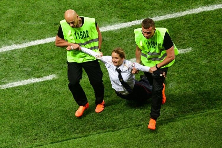 Anggota kelompok Pussy Riot, diaman oleh petugas keamanan pada pertandingan final Piala Dunia 2018  di Stadion Luzhniki di Moskwa, Rusia, Minggu (25/7/2018). (AFP/Mladen Antonov)