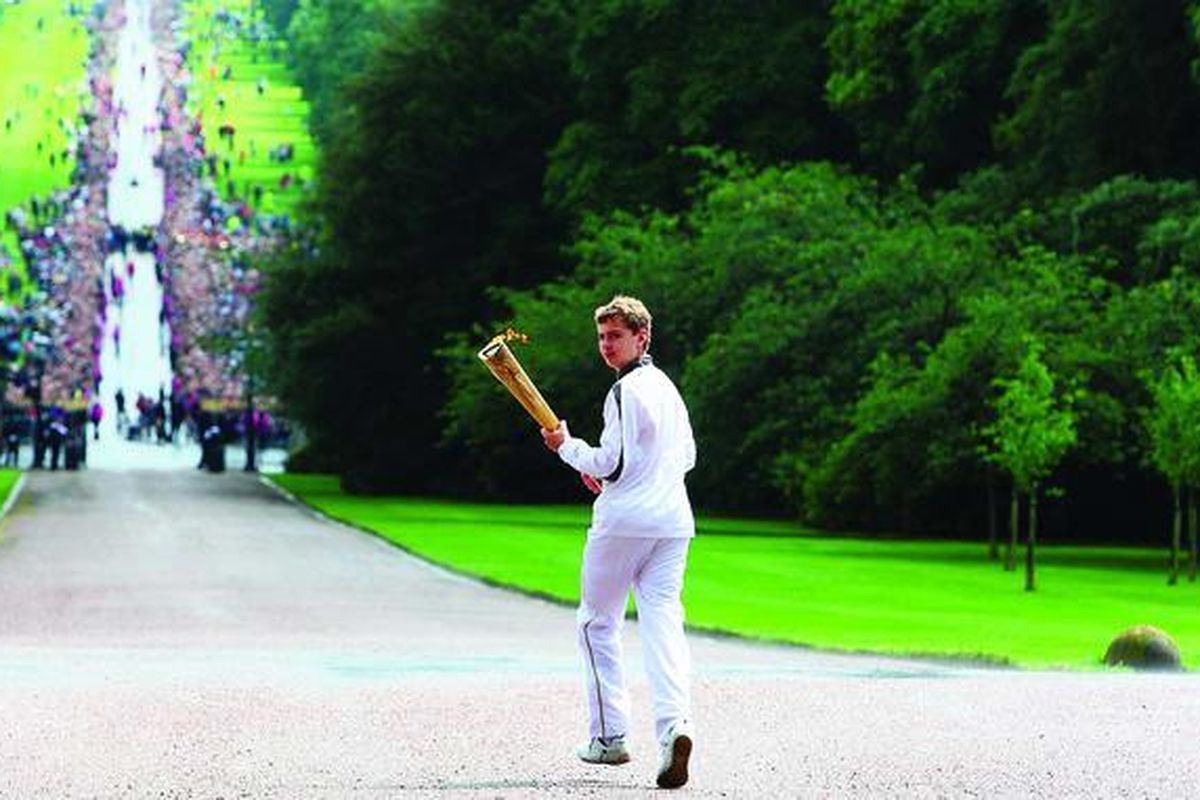 Pembawa obor Olimpiade London 2012, Phillip Wells, berlari di jalan dalam lingkungan Kastel Windsor di barat London, Selasa (10/7).