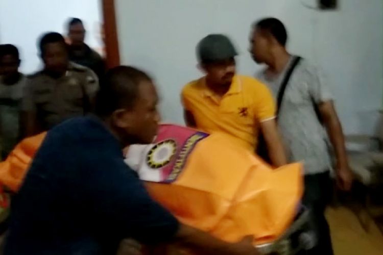 Anggota Polres Pamekasan saat mengevakuasi kedua mayat dari dalam kamar hotel Garuda, Kamis (24/1/2019) malam.