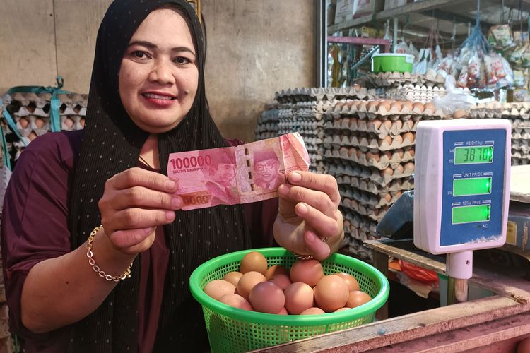 Mulyati, pedagang telur di Pasar Jati Asih, Kota Bekasi menunjukkan uang palsu yang ia terima saat berdagang. Minggu (9/1/2022) 