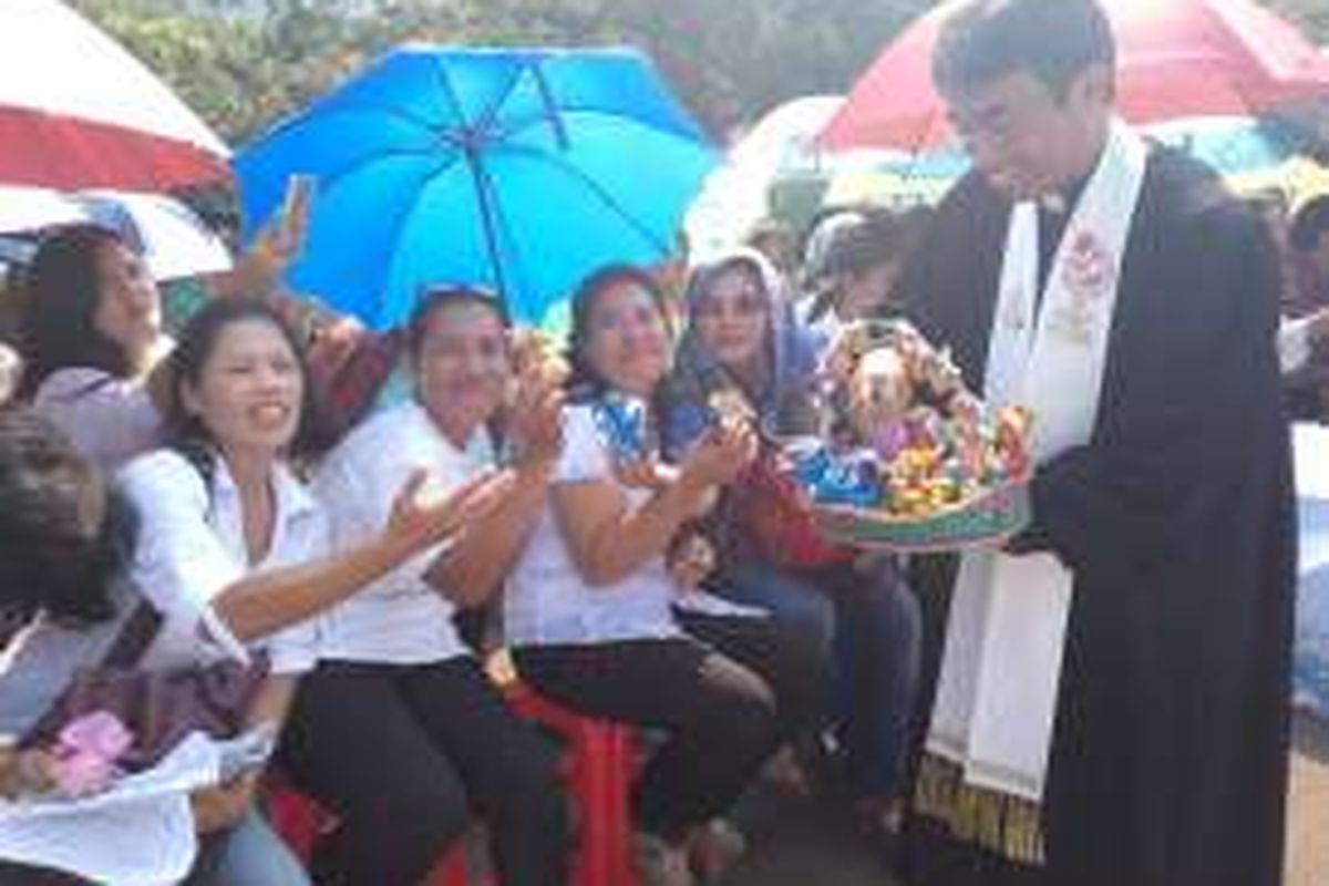 Suasana saat salah satu pendeta membagikan telur Paskah kepada para jemaat dari GKI Yasmin dan HKBP Filadelfia di seberang Istana Negara, Jakarta Pusat pada Minggu (27/3/2016). Ratusan jemaat dari kedua gereja tersebut terpaksa melakukan ibadah Paskah dilokasi tersebut karena Gereja mereka masih disegel oleh Pemerintah Daerah Bogor dan Pemerintah Daerah Bekasi. 