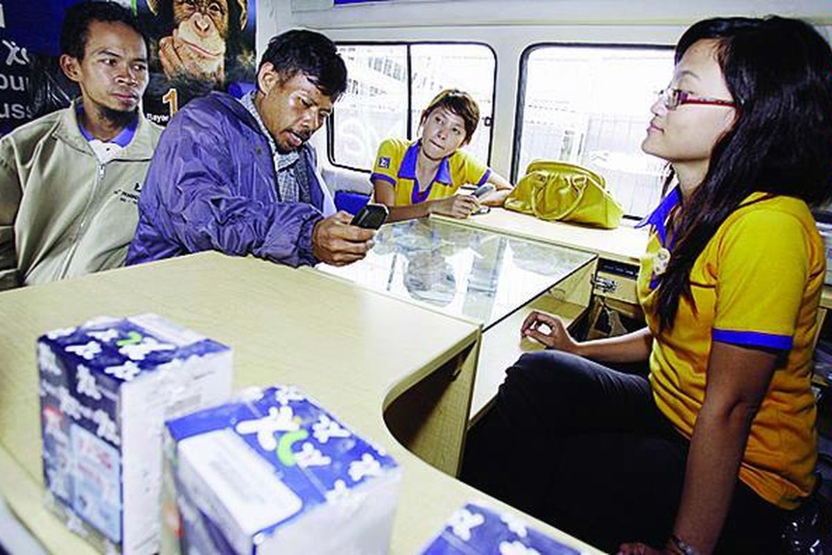 Staf salah satu operator seluler nasional melayani pelanggan di mobil pelayanan di kawasan Buaran, Jakarta, Senin (29/12). Sejumlah operator seluler menggunakan strategi pelayanan dengan menjemput konsumen di pusat keramaian di tengah persaingan antaroperator guna meraih pelanggan sebanyak-banyaknya.  