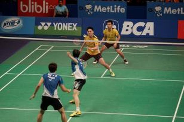Pasangan ganda putra Malaysia, Tan Boon Heong/Tan Wee Kiong (kuning) bertahan menghadapi serangan ganda Korea, Lee Yong-dae/Yoo Yeon-seong, pada perempat final BCA Indonesia Open Superseries Premier 2014, Jumat (20/6/2014).