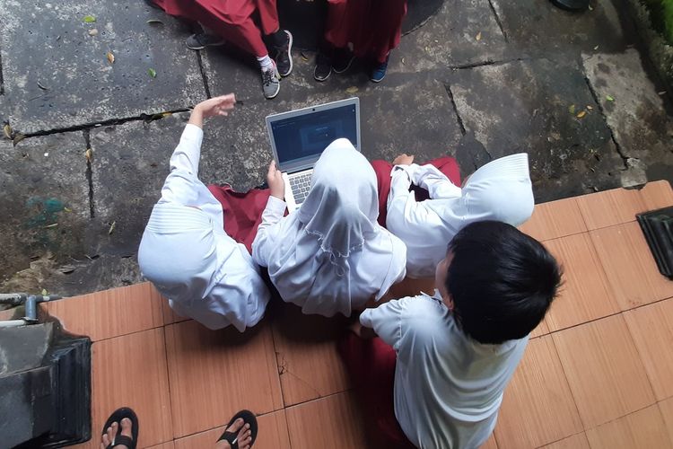 Siswa SD N 1 Wonosari, Gunungkidul, Sedang Belajar Melalui Laptop di Halaman Sekolah Selasa (10/3/2020)