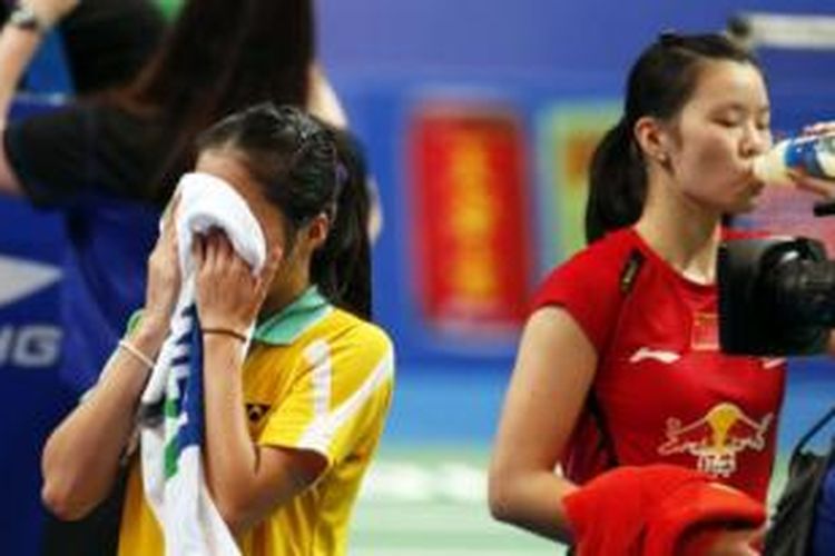 Tunggal putri China, Li Xuerui (kanan), beristirahat untuk minum saat jeda pertandingan melawan tunggal Thailand, Ratchanok Intanon, pada babak final BWF World Championships 2013 di Guangzhou, China, Minggu (11/8/2013). 