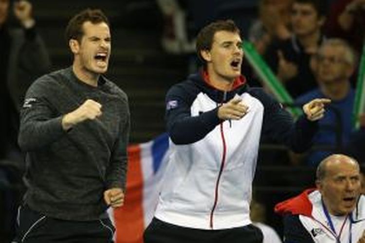 Petenis Inggris, Andy Murray (kiri), dan sang kakak, Jamie Murray, memberi semangat kepada James Ward yang sedang bertanding melawan John Isner dari Amerika Serikat pada babak pertama Piala Davis di Glasgow, Jumat (6/3/2015).
