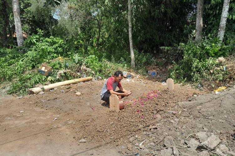 Seorang warga tengah berdoa di makam siswa yang diduga korban tawuran di Karawang Barat, Karawang, Jawa Barat, Sabtu (12/8/2023).