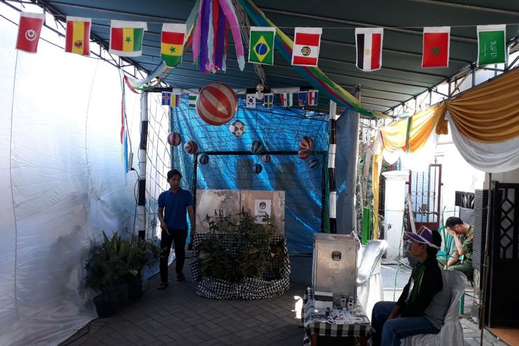 Pemilih mencoblos di dalam gawang di TPS Piala Dunia Surabaya