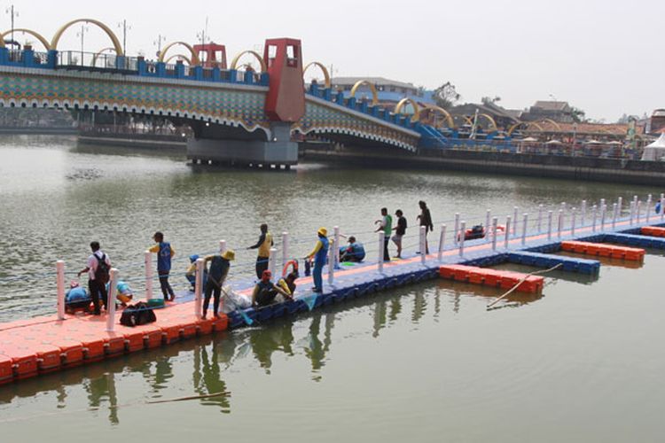 Sejumlah pekerja melakukan pengerjaan pemasangan jembatan apung yang akan digunakan untuk pelaksanaan Festival Cisadane 2019 di Sungai Cisadane, Tangerang, Rabu (24/7/2019). Festival yang sudah menjadi 100 event yang masuk dalam kalender Kementerian Pariwisata ini berlangsung 26 Juli 2019 hingga 3 Agustus 2019 dengan menghadirkan Lomba Perahu Naga, Lomba Dayung, kesenian tradisional Tangerang serta Kuliner Tangerang, lomba dayung ini rencananya juga akan diikuti peserta dari sejumlah negara sahabat.