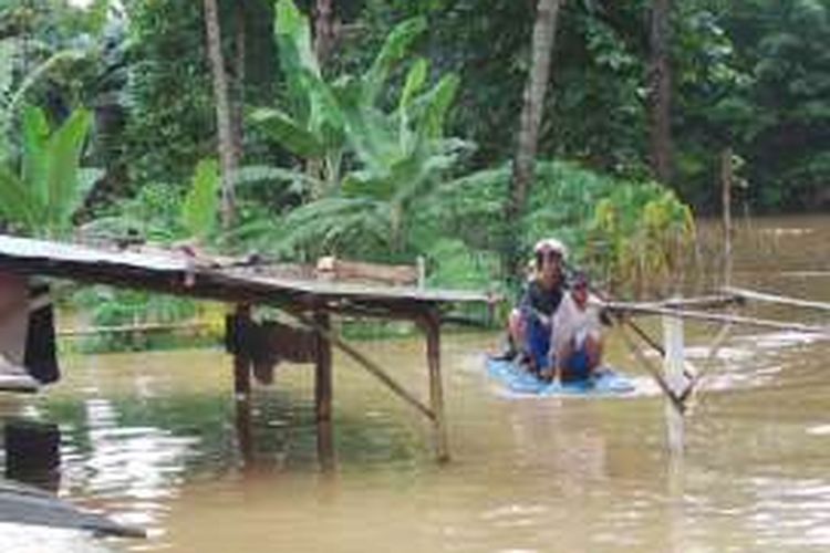 Warga Gang Arus di Cawang menggunakan perahu tradisional untuk beraktivitas saat banjir akibat Ciliwung meluap. Selasa (8/3/2016)