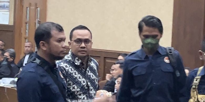 Mantan Aide-de-camp (ADC) atau ajudan eks Menteri Pertanian (Mentan) Syahrul Yasin Limpo (SYL), Panji Harjanto (mengenakan batik) mendapat perlindungan fisik dari Lembaga Perlindungan Saksi dan Korban (LPSK) saat bersaksi di Pengadilan Tindak Pidana Korupsi (Tipikor) pada Pengadilan Negeri (PN) Jakarta Pusat, Rabu (17/4/2024).