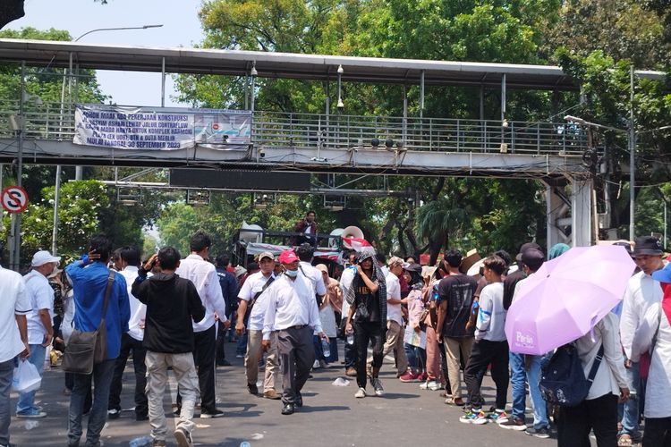 Massa aksi diminta membubarkan diri oleh orator di depan Jembatan Penyeberangan Orang (JPO) Jalan Medan Merdeka Barat, Gambir, Jakarta Pusat, Senin (16/10/2023). (KOMPAS.com/XENA OLIVIA)