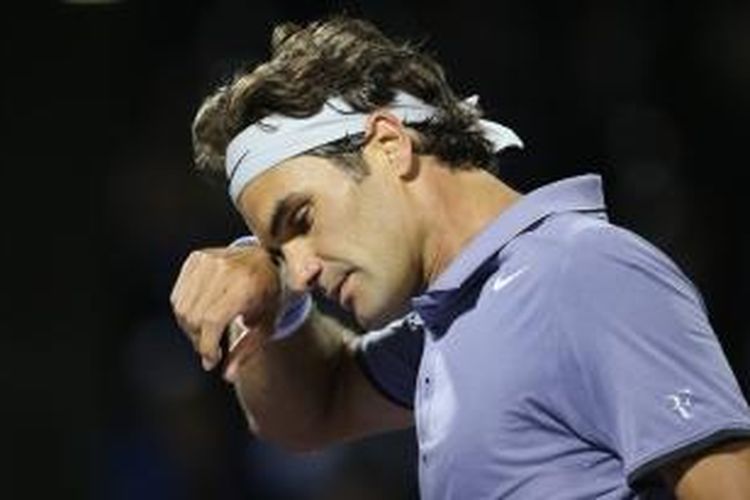Petenis Swiss Roger Federer mengelap keringat saat menghadapi Kei Nishikori dari Jepang pada perempat final Sony Open di Crandon Park Tennis Center, Miami, Rabu (26/3/2014). Federer kalah 6-3, 5-7, 4-6.