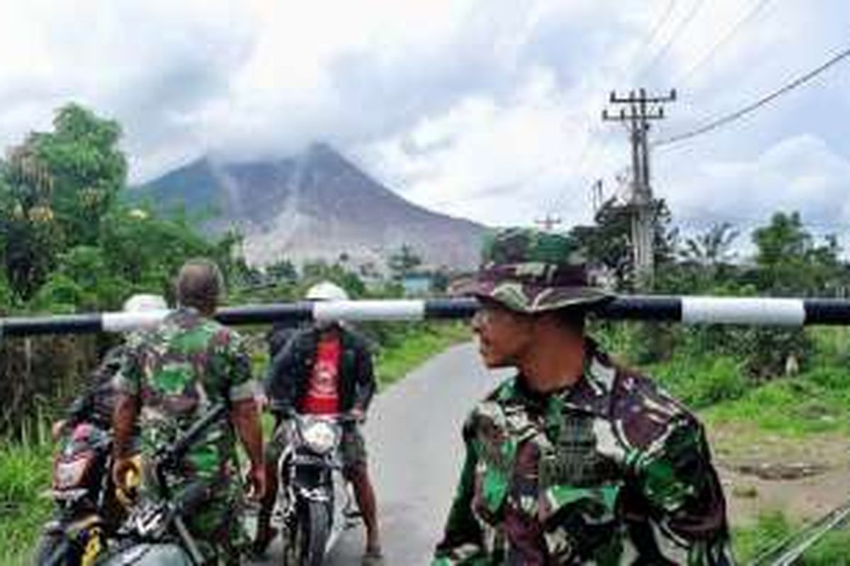 Petugas memperingatkan dua warga yang hendak keluar dari zona merah erupsi Sinabung di portal simpang Sibintun, Kecamatan Simpang Empat, Kabupaten Karo, Rabu (2/11/2016). Meskipun status Gunung Sinabung Awas dan potensi erupsi dan luncuran awan panas tinggi, peringatan untuk tidak beraktivitas di zona merah Sinabung masih terus dilanggar warga.