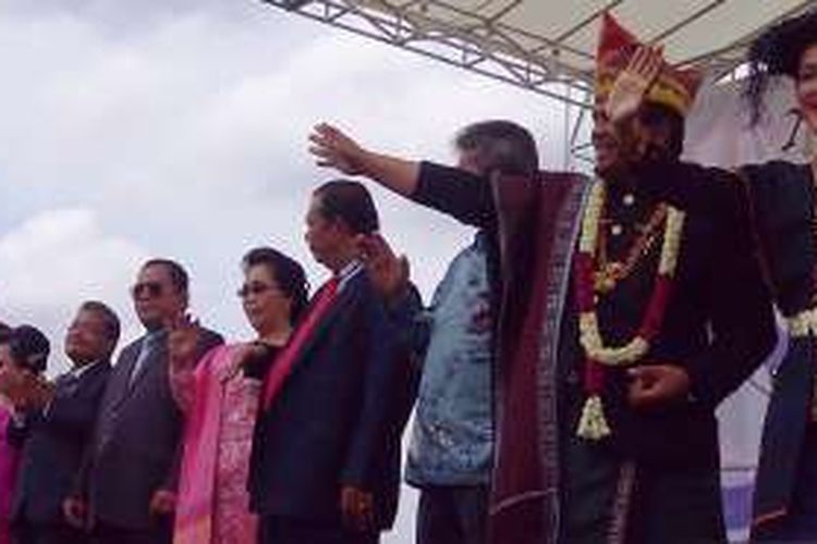 Bupati Dairi melambaikan tangan kepada peserta defile pada Pesta Oang-Oang di Kecamatan Sidikalang, Minggu (28/8/2016).