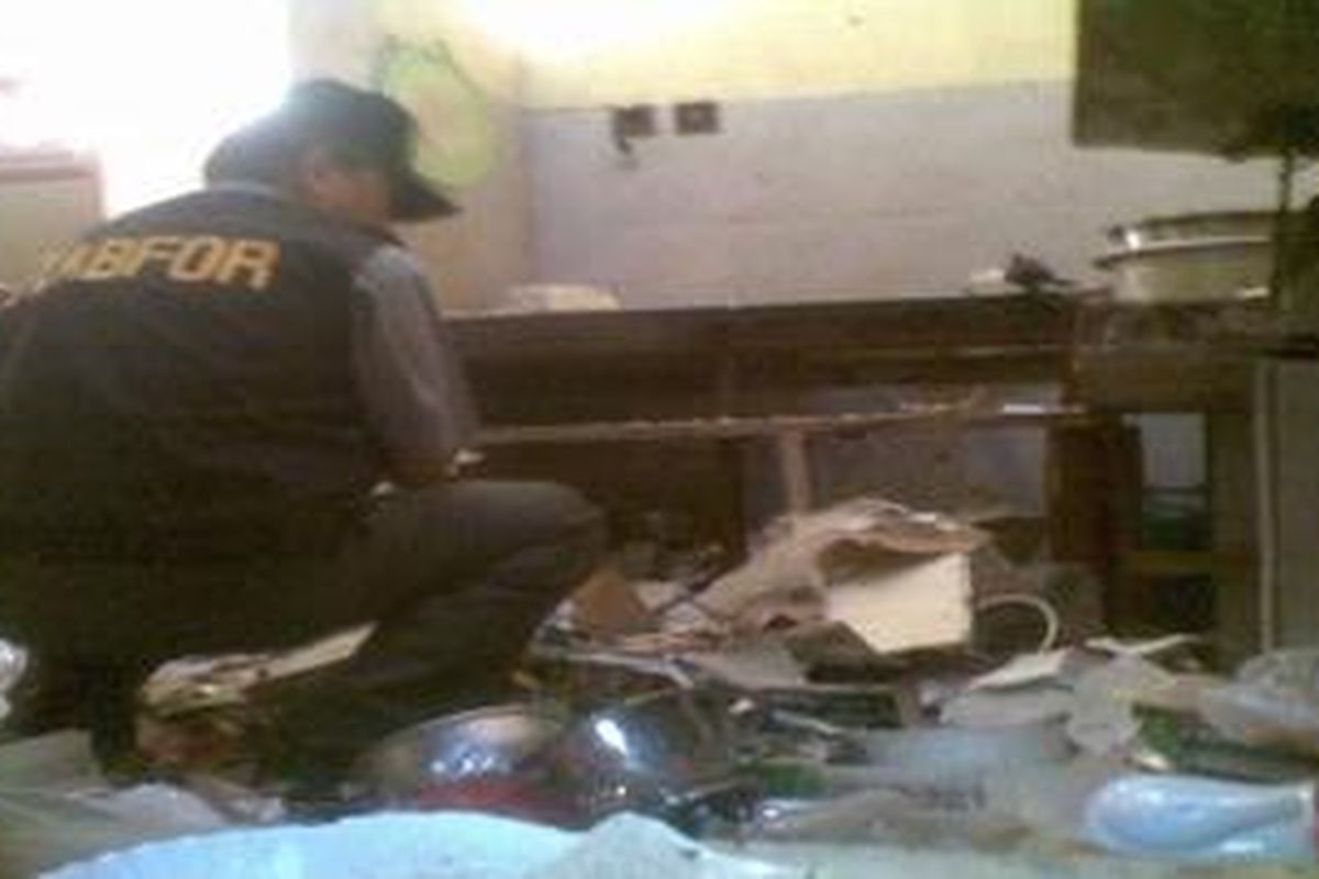 Petugas Laboratorium Forensik tengah memeriksa lokasi ledakan keras di Kediri, Jumat (6/4/2012).