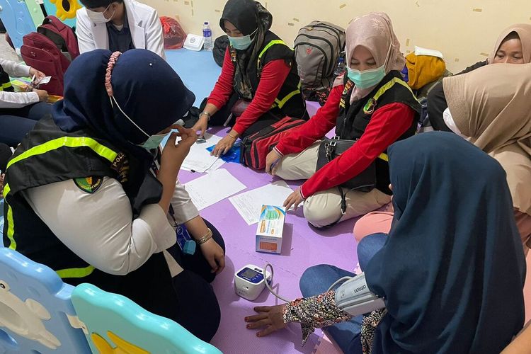 Proses pemeriksaan kesehatan calon pekerja migran asal NTB yang menjadi korban TPPO di Mapolda Lampung, Selasa (6/6/2023) malam.
