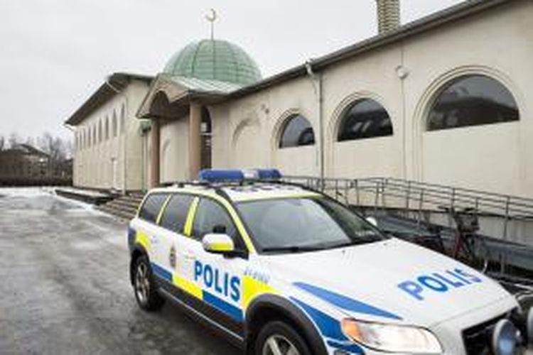 Mobil polisi di depan masjid di Uppsala, Swedia, setelah serangan bom molotov pada Kamis (1/1/2015) dini hari. Dalam sepekan terakhir, setidaknya tiga serangan terhadap masjid terjadi di Swedia. 