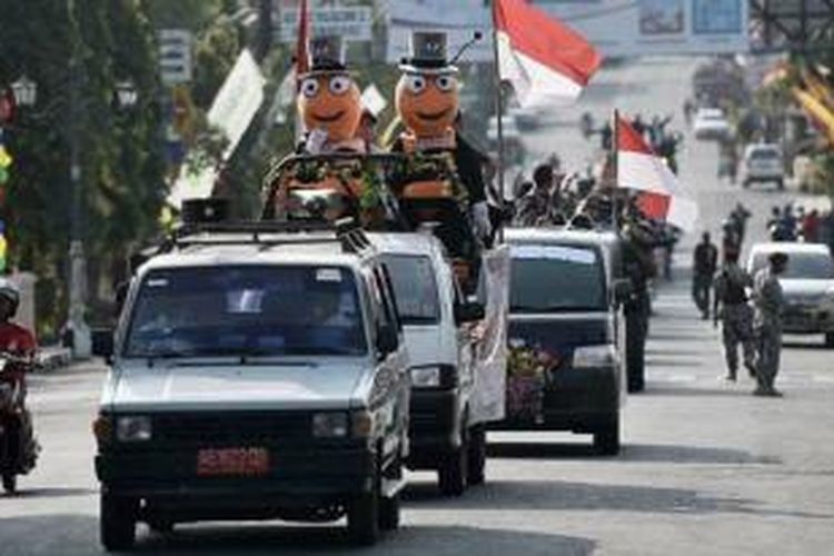 Iring-iringan kendaraan pasangan calon peserta Pilkada Gunung Kidul, DI Yogyakarta, yang diawali dengan maskot Komisi Pemilihan Umum Gunung Kidul, menandai hari pertama kampanye, Kamis (27/8/2015). Empat pasang calon bupati-wakil bupati Gunung Kidul akan berkampanye selama 101 hari untuk meraih suara terbanyak dalam pilkada pada 9 Desember 2015.