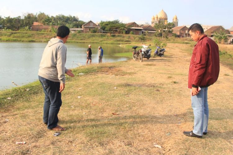 Kapolres Gresik, Jawa Timur, AKBP Wahyu Sri Bintoro (kanan), saat melihat olah TKP miras oplosan di Desa Hulaan, Kecamatan Menganti, Minggu (19/8/2018).