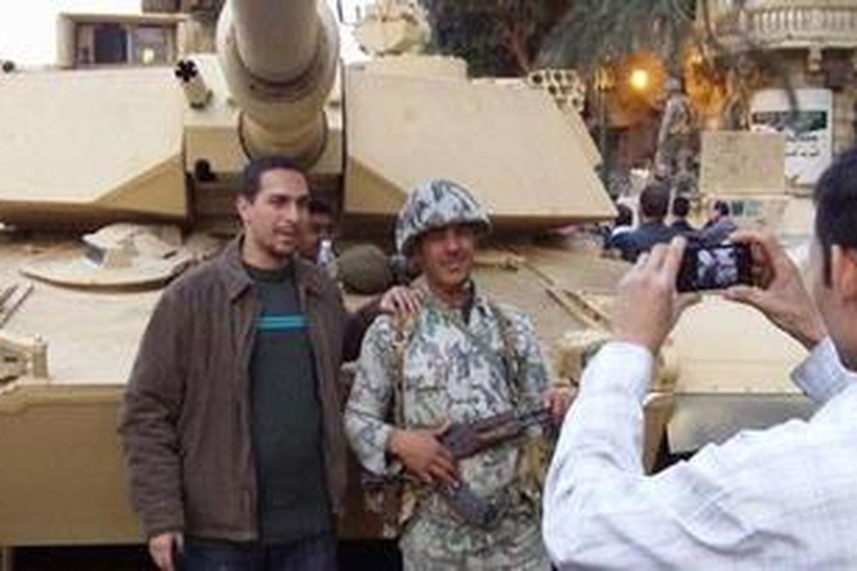Foto seorang demonstran di Mesir bersama seorang tentara yang diambil oleh Nicholas D. Kristof dan disebar di http://twitpic.com/3v8vs1/full