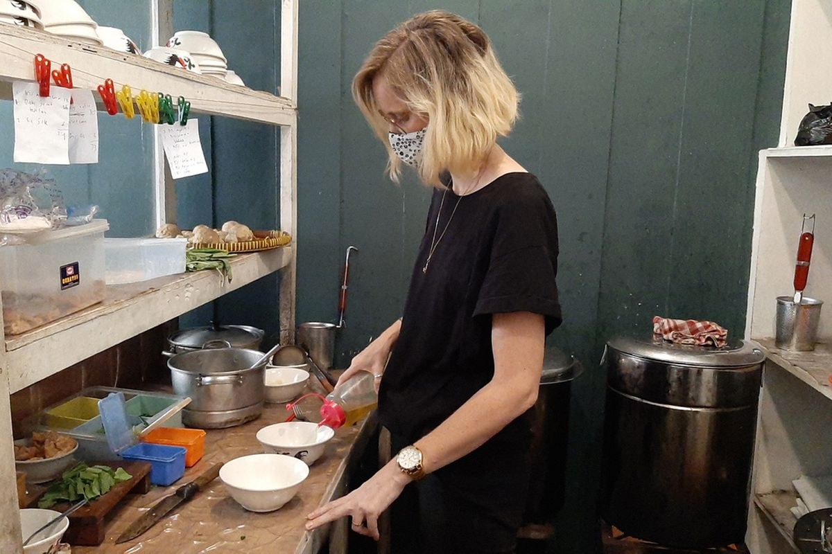 Charlotte Peeters while cooking chicken noodles at her stall.