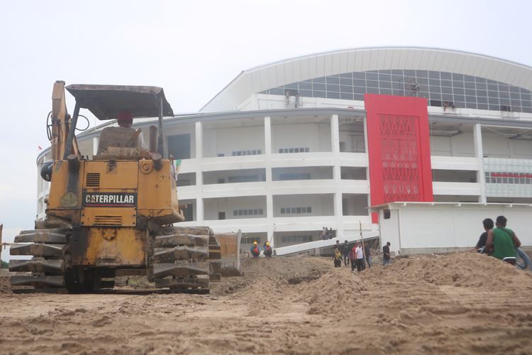 Alat berat meratakan tanah timbun di akses jalan berkubang menuju venue voli Indoor di Sport Center Sumut, di Desa Sena, Deli Serdang, Selasa (10/9/2024)