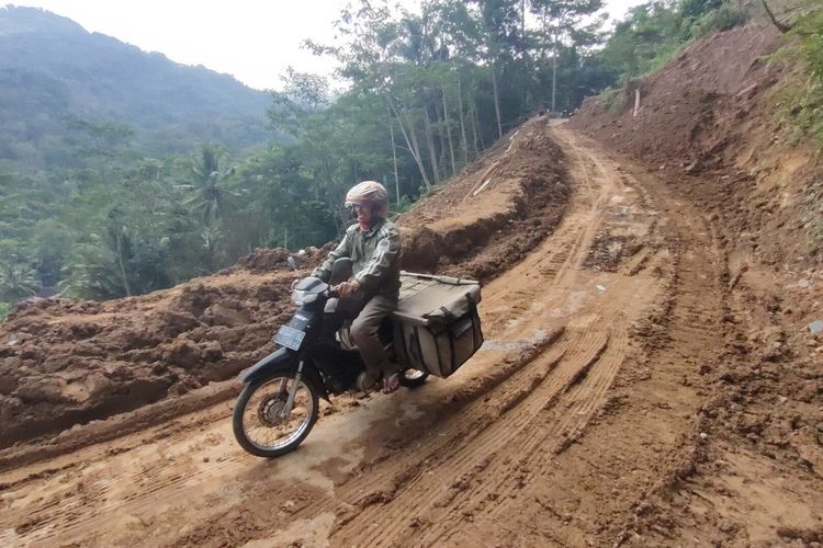 Sejumlah warga coba melintasi jalan yang tadinya tertutup tanah longsor di Plampang II, Kalurahan Kalirejo, Kapanewon Kokap, Kabupaten Kulon Progo, Daerah Istimewa Yogyakarta. Jalan ini diperkirakan normal Rabu (25/5/2022) besok.