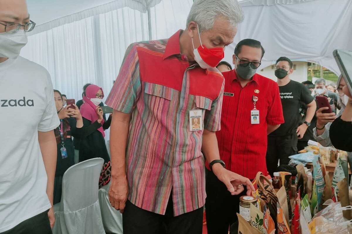 Gubernur Jawa Tengah Ganjar Pranowo mengulas produk UMKM saat membuka Bootcamp Gerakan Akar Digital Indonesia bagi 150 pelaku UMKM, di Desa Kandri, Kota Semarang, Selasa (20/9/2022).