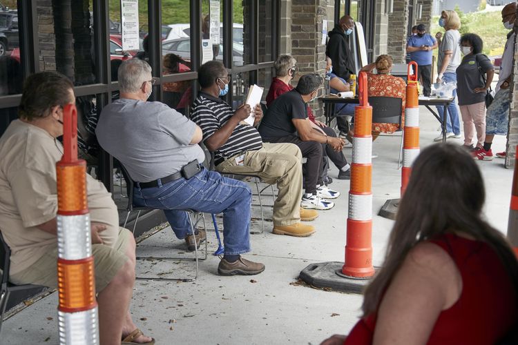 Dalam file foto tanggal 15 Juli 2020 ini, para pencari kerja melakukan latihan jarak sosial saat mereka menunggu untuk dipanggil ke kantor Heartland Workforce Solutions di Omaha, Neb. Proposal Partai Republik untuk memangkas peningkatan manfaat mingguan sebesar $ 600 bagi mereka yang tidak memiliki pekerjaan karena virus corona penutupan dapat mengakibatkan pembayaran tertunda berminggu-minggu atau bahkan berbulan-bulan di beberapa negara bagian.