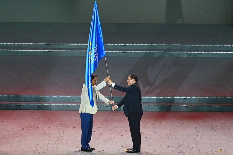 Menteri Kebudayaan, Olahraga, dan Pariwisata Vietnam Nguyen Van Hung (kanan) menyerahkan bendera SEA Games kepada perwakilan Kamboja pada upacara penutupan SEA Games 2021 Vietnam, pada 23 Mei 2022. 