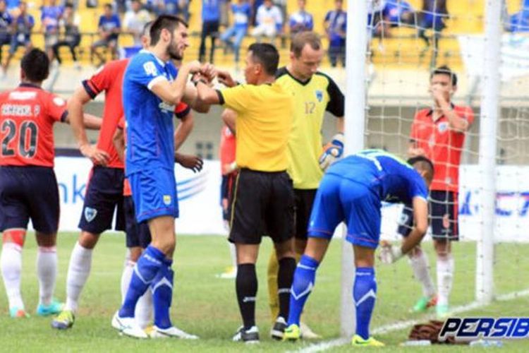 Penyerang Persib Bandung, Ferdinand Sinaga, memprovokasi kiper Pelita Bandung Raya, Dennis Romanovs, dalam pertandingan Indonesia Super League (ISL), Selasa (20/5/2014). 