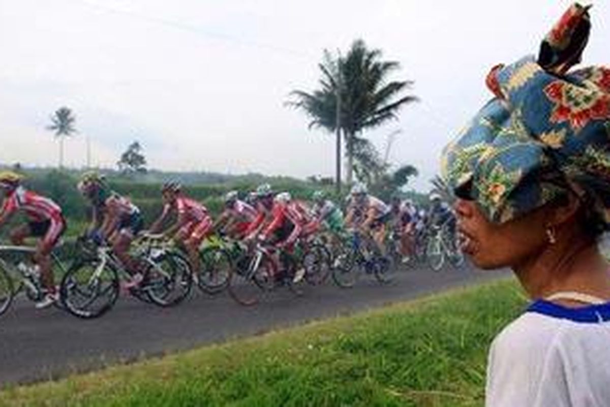 Petani melihat peserta balap sepeda Tour de Singkarak 2011 saat menjalani etape 6B dari Istano Basa Pagaruyung menuju Padang Panjang, Sumatera Barat, Sabtu (11/6/2011). Etape keenam dibagi menjadi dua sesi, yaitu 6A dan 6B. Pada etape 6A sejauh 94,6 kilometer dimenangkan oleh Yiming Zhao dari Holy Brother Racing Team China dengan catatan waktu 2 jam 16 menit 52 detik. Sedangkan untuk etape 6B sejauh 39 kilometer dimenangkan oleh Golakhour Pourseyedi dari Azad University Iran dengan catatan waktu 1 jam 4 menit 24 detik. 