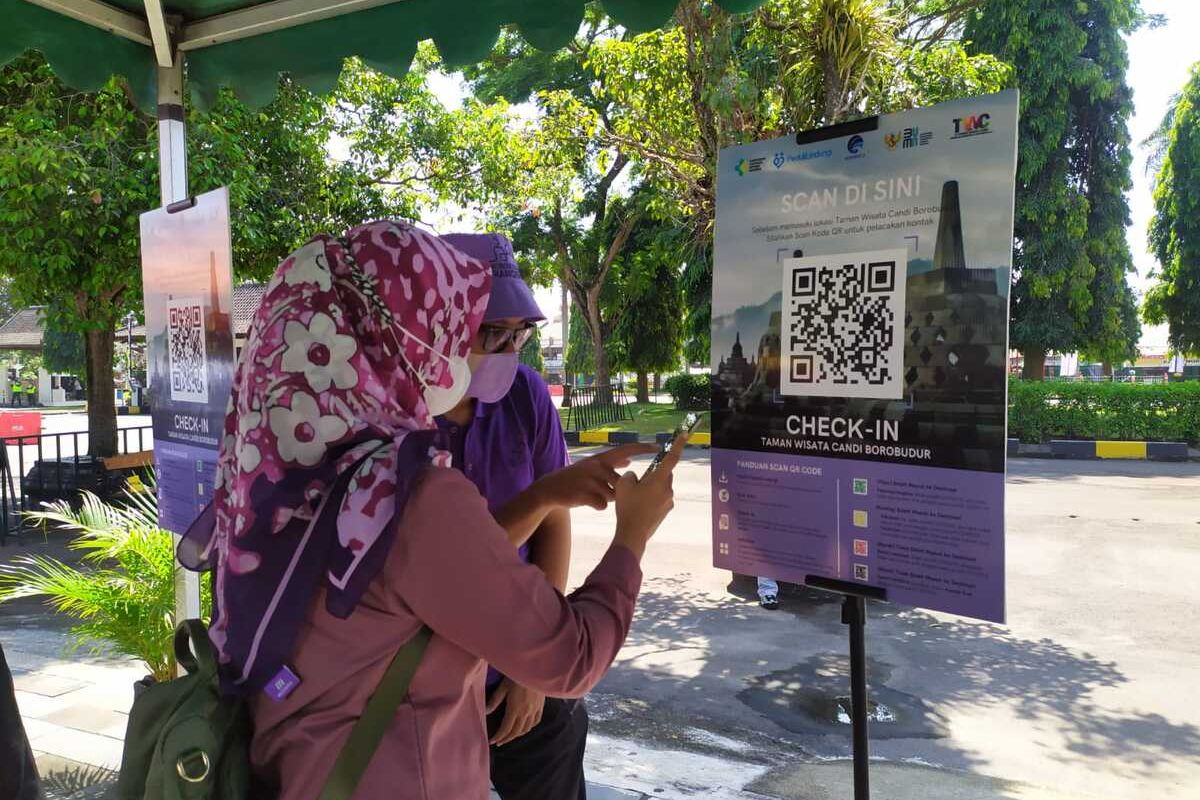 Seorang wisatawan dipandu petugas scan barcode aplikasi PeduliLindungi sebelum masuk Taman Wisata Candi Borobudur Magelang, Jawa Tengah, Jumat (17/9/2021)