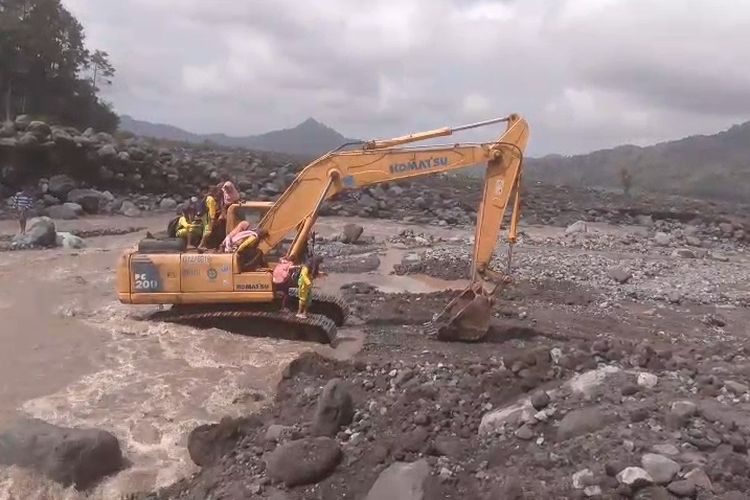 Siswa SDN Jugosari 3 sebrangi lahar hujan menaiki beko untuk pulang ke rumahnya, Sabtu (2/8/2025)