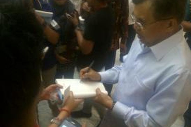 Wapres JK menandatangani buku Ombak Perdamaian yang dibagikan ke wartawan, sebelum meninggalkan kantor wapres, Selasa, 23 Desember 2014