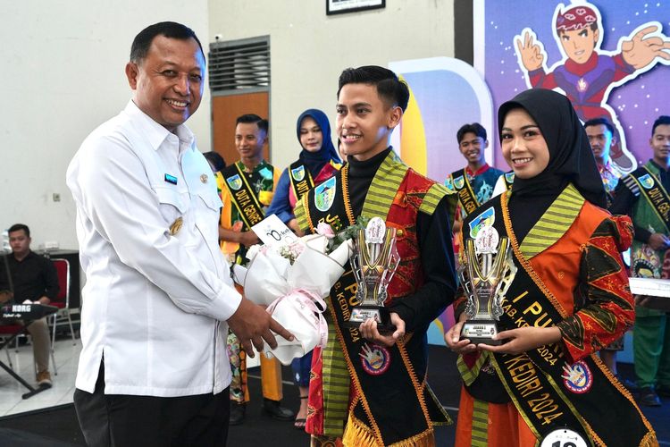 Pjs Bupati Kediri Heru Wahono Santoso saat menyerahkan Piala Juara 1 Duta Genre 2024 di Gedung Bagawanta Bhari, Kabupaten Kediri, Rabu (20/11/2024).