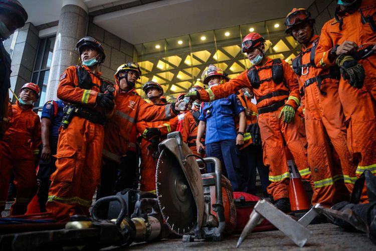 Tim Basarnas keluar gedung Tower II setelah mengevakuasi korban di dalam gedung Bursa Efek Indonesia di Jakarta, Senin (15/1/2018). Sebanyak 72 orang menjadi korban akibat robohnya selasar tower II Gedung Bursa Efek Indonesia dan telah dievakuasi ke beberapa rumah sakit.