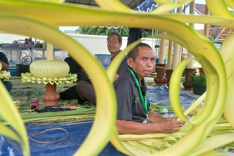Sejumlah orang sedang merangkai janur menjadi ornamen-ornamen dhaup ageng di sekitar Pura Pakualaman, Senin (8/1/2024)