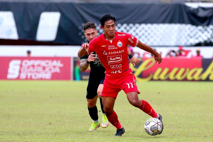 Pemain Persija Jakarta Firza Andika dijaga ketat pemain Persebaya Surabaya saat pertandingan pekan ke-15 Liga 1 2022-2023 yang berakhir dengan skor 1-1 di Stadion Maguwoharjo Sleman, Jumat (16/11/2022) sore.
