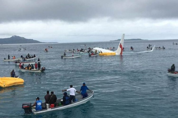 Penduduk setempat mendekati pesawat dengan menggunakan perahu kecil untuk menyelamatkan penumpang dari pesawat Air Niugini yang jatuh di pulau terpencil Weno, di Mikronesia, Jumat (28/9/2018). (AFP/James Yaingeluo)