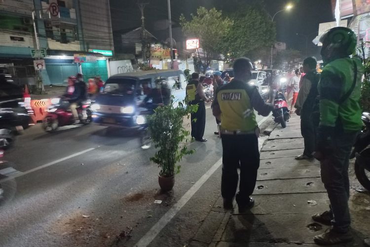 Petugas Laka Lantas Polres Metro Depok tengah mengecek lokasi kecelakaan di Jalan Arif Rahman Hakim, Jumat (28/10/2022).