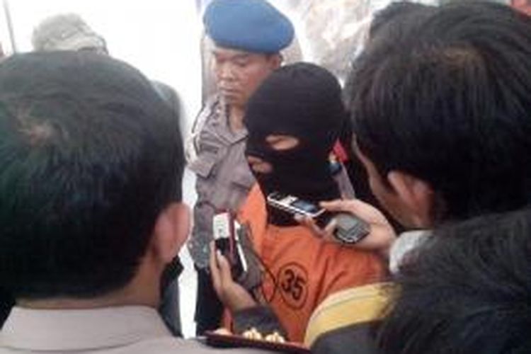 Zainul Ibad (22), tersangka pembunuhan terhadap seorang janda Eko Rovita (32) saat ekspos kasus di Mapolres Kediri Kota, Jawa Timur, Minggu (16/3/2014).